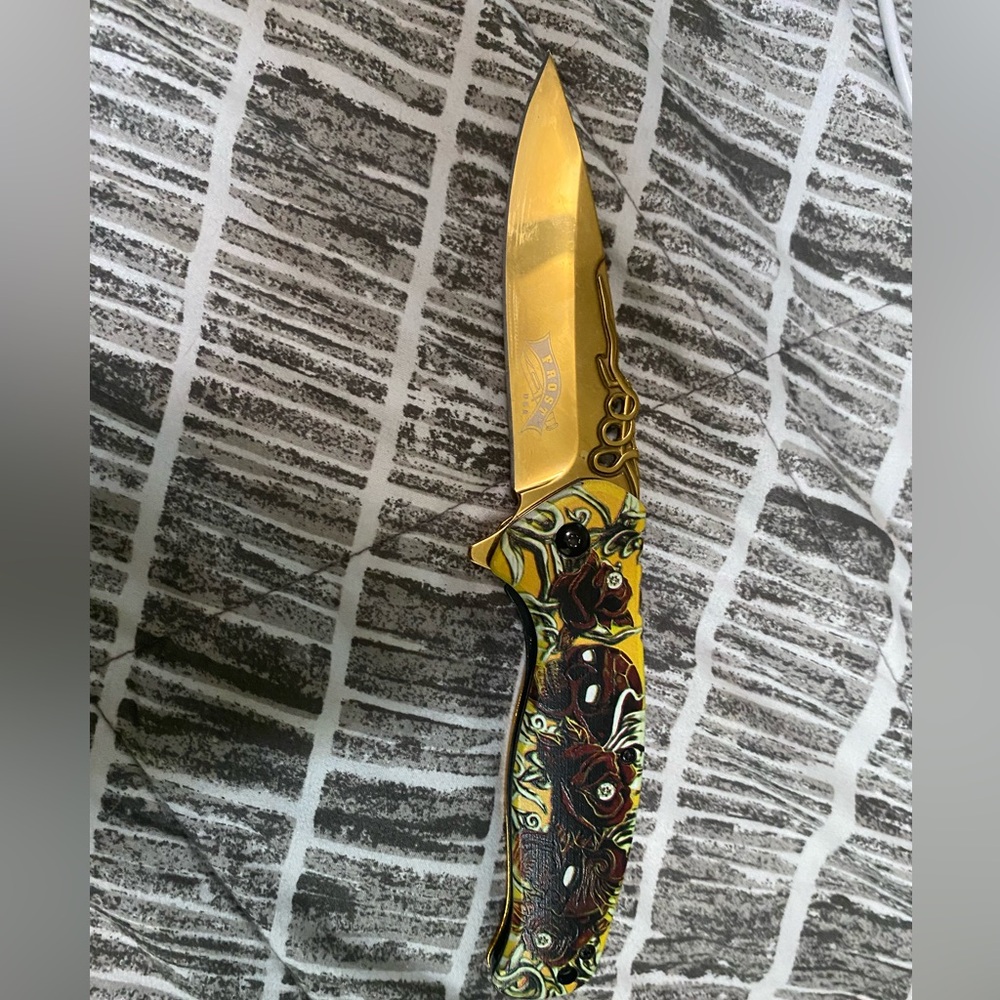 Gold colored knife with design for sale